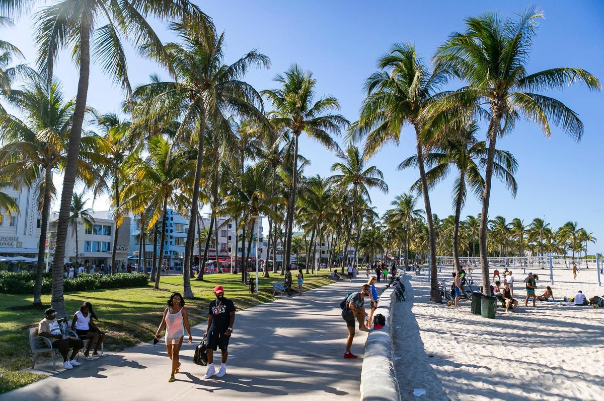 Beachgoers make their way through Lummus Park in Miami Beach, Florida during the start of Memorial Day Weekend on Friday, May 28, 2021.
