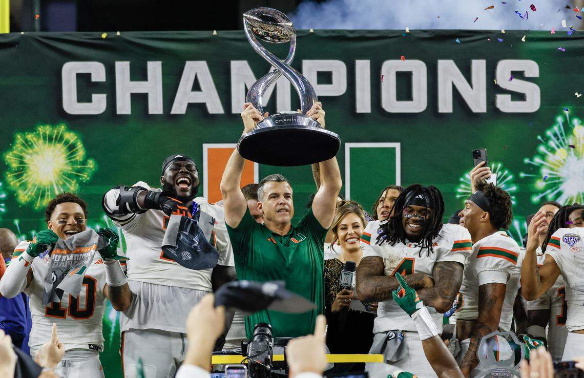 Miami Hurricanes head coach Mario Cristobal lifts the Cotton Bowl Championship Trophy after the College Football Playoff quarterfinal game at AT&T Stadium in Arlington, Texas on Wednesday, December 31, 2025.