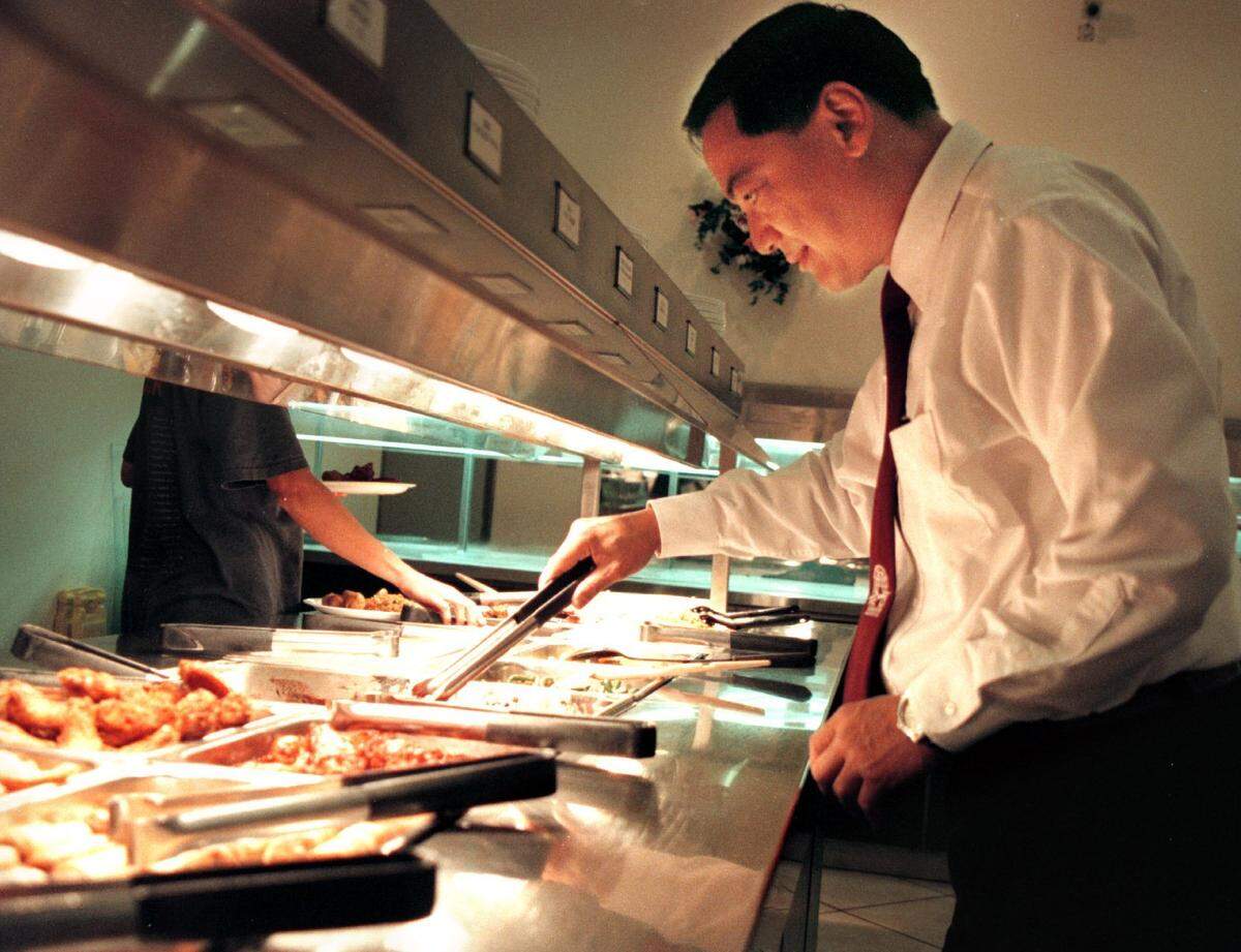 David Sham, manager of DuBarry Chinese Buffet in Plantation, stirs some of the 200 Chinese, American and Italian dishes the all-you-can eat restaurant in 2001.