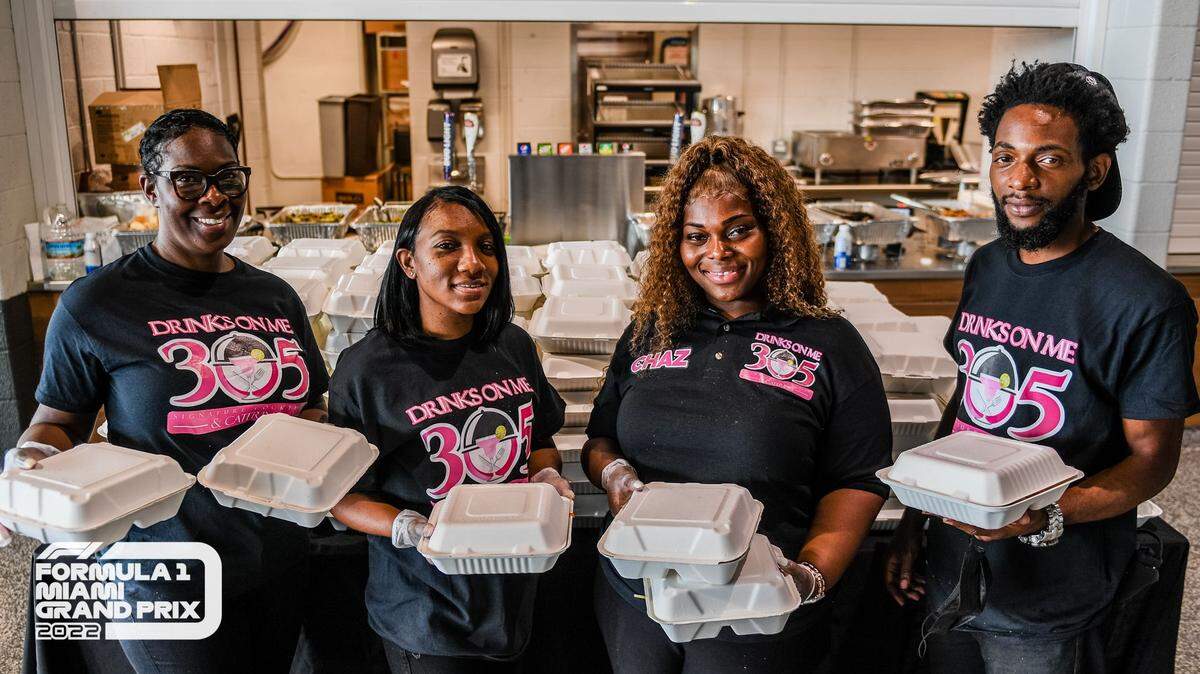 Chazemon “Chaz” Fenderson (second from right) and her DrinksOnMe305 staff distribute meals through the Miami Dolphins Food Relief Program.