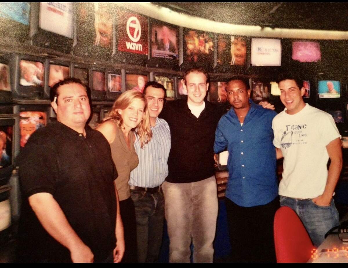 Mike McCormick, pictured in the center wearing a black polo, along with fellow copy writers at Miami's WSVN-7 in the early 2000s. He went on to become a news reporter in South Carolina, and was killed Monday by a falling tree while on assignment.