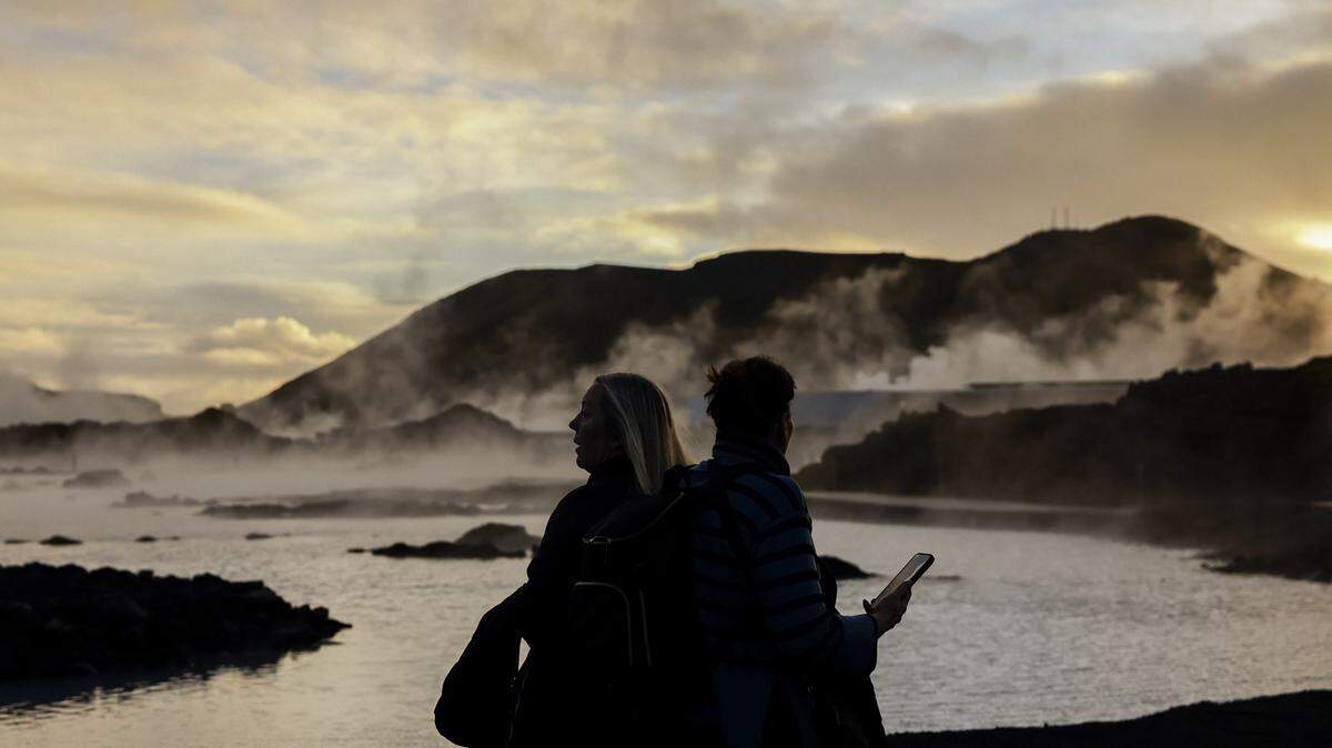 People watch as steam rises from the Blue Lagoon tourist attraction on December 13, 2025 in Grindavik, Iceland.