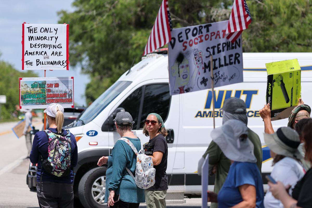 Protesters watch as an ambulance leaves Alligator Alcatraz on Saturday, July 12, 2025 in Ochopee.