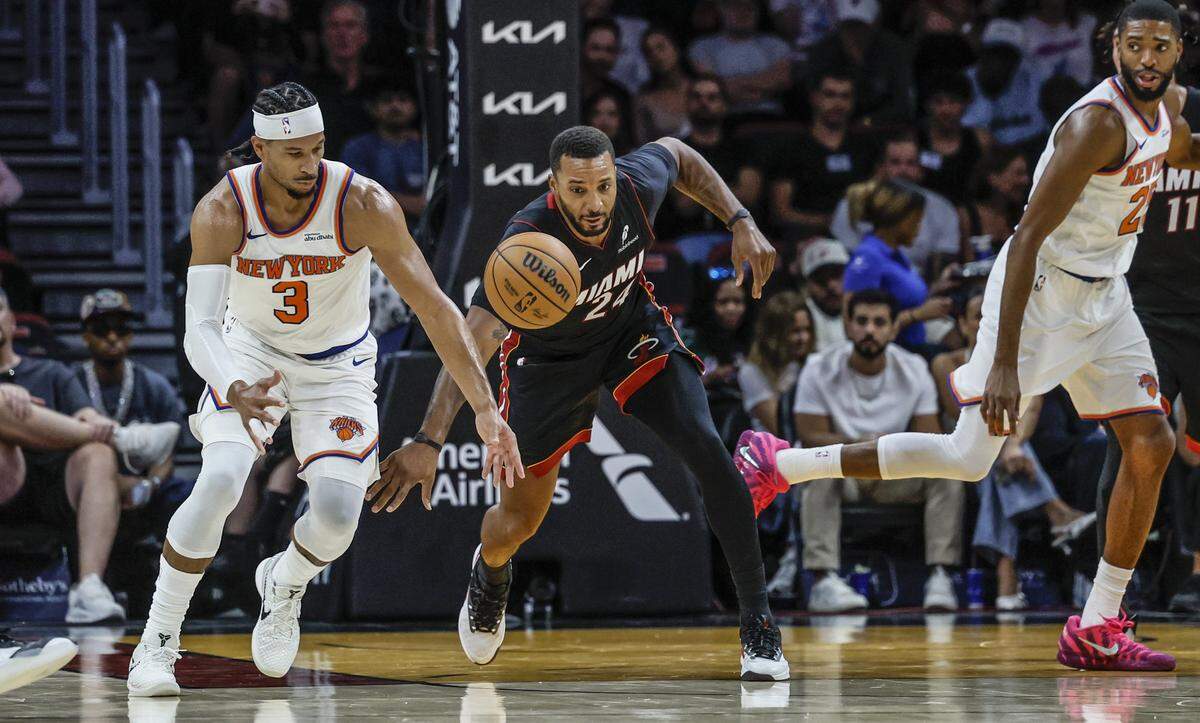 Miami Heat guard Norman Powell (24) and New York Knicks guard Josh Hart (3) chase a lose ball during the first half of their NBA basketball game at Kaseya Center in Miami on October 26, 2025.