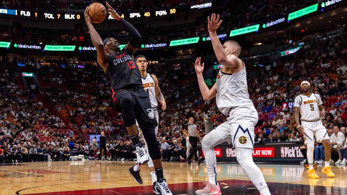 Miami Heat center Bam Adebayo (13) shoots a fade away while defended by Denver Nuggets center Nikola Jokic (15) during the first half of an NBA game at Kaseya Center in Miami, Florida, on Wednesday, March 13, 2024.
