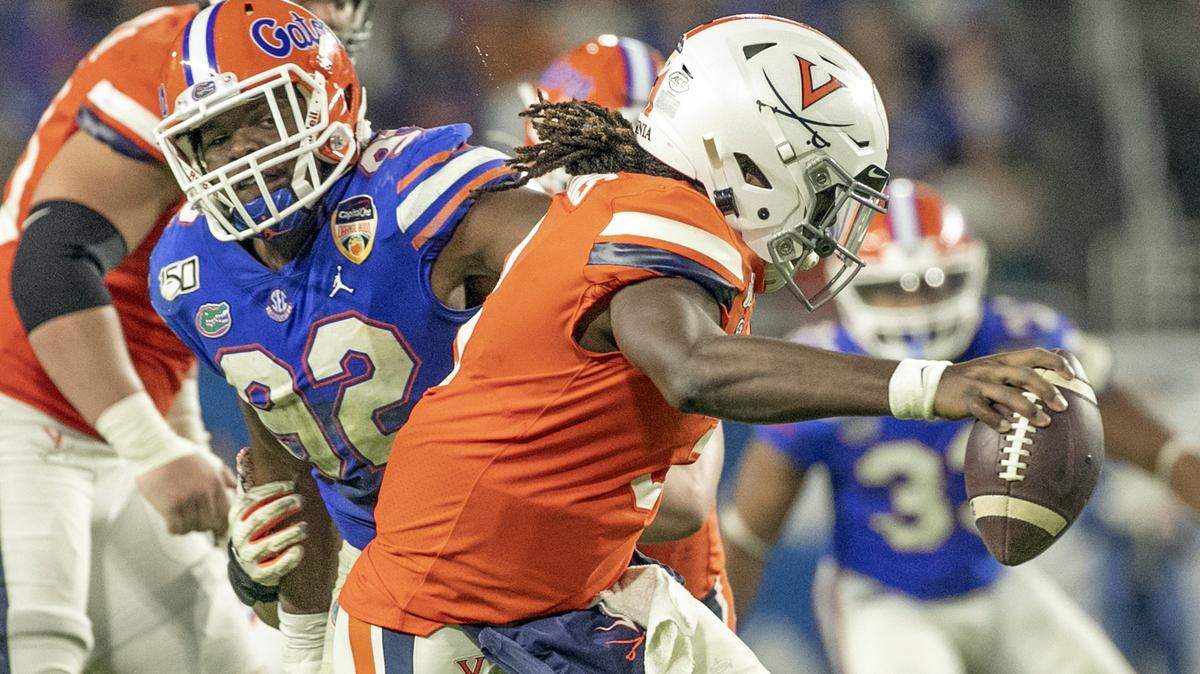 Florida Gators defensive lineman Jabari Zuniga (92) puts pressure on Virginia Cavaliers quarterback Bryce Perkins (3) in the second quarter as the Florida Gators play the Virginia Cavaliers during the Capital One Orange Bowl at Hard Rock Stadium in Miami Gardens on Monday, December 30, 2019.