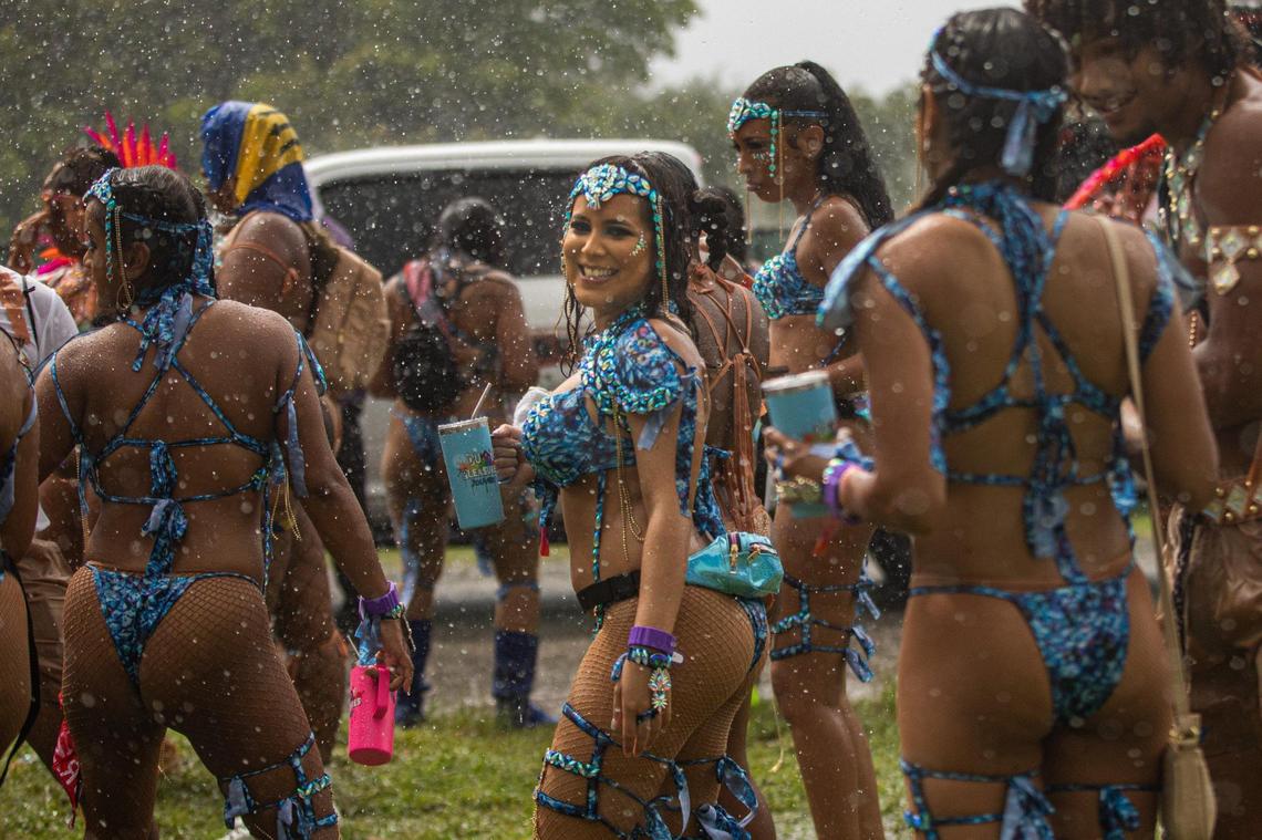 Performers walk in the rain during Miami Carnival at the Miami-Dade County Fair Expo in Miami, Florida on Sunday, October 9, 2022.