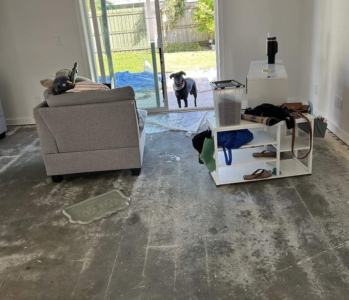 All of the floor panels were ripped out of Joanna and Matthew Weddleton’s home. Their 5-year old rescue, Jenny, looks in through the sliding door.