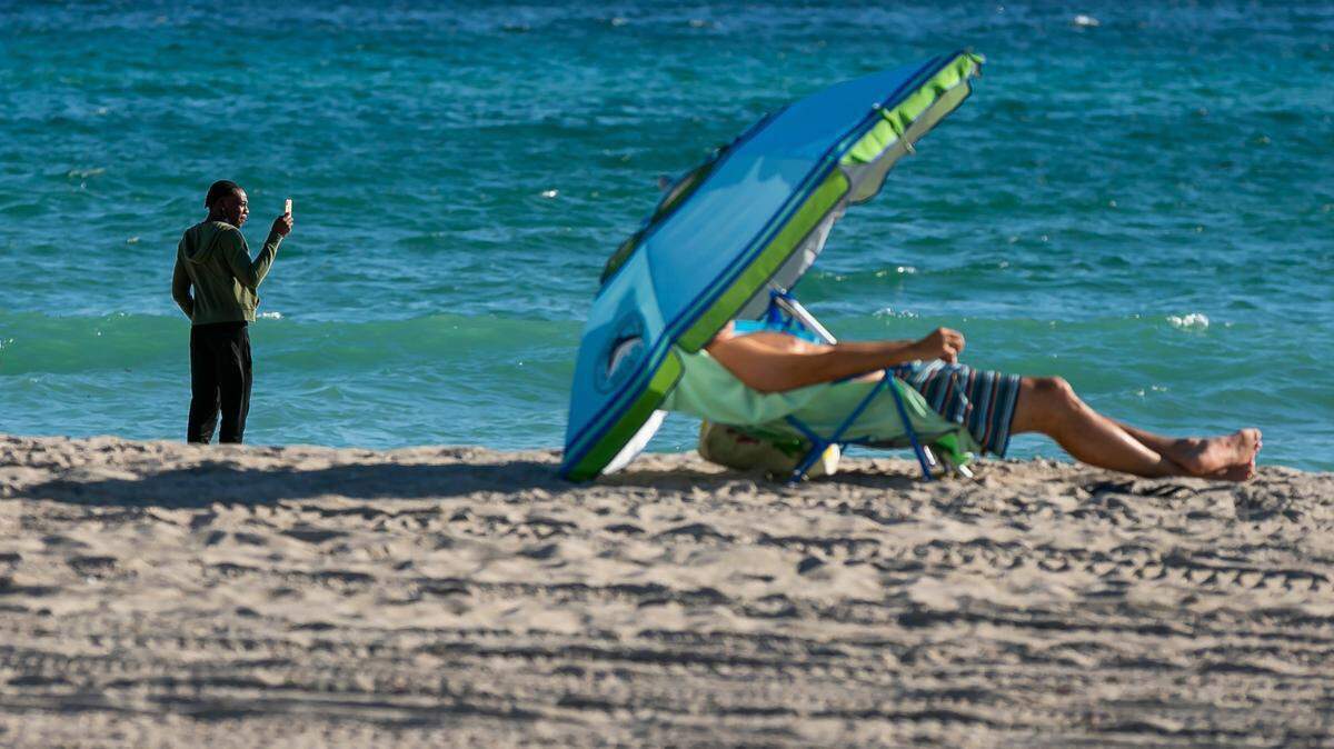 People visit Hollywood Beach after temperatures dipped into the mid-50s and low 60s across South Florida on Tuesday, Dec. 1, 2020.