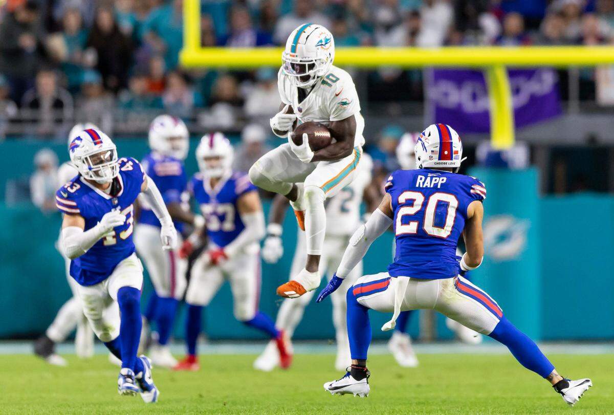 Miami Dolphins wide receiver Tyreek Hill (10) catches the ball as Buffalo Bills safety Taylor Rapp (20) looks to tackle in the second quarter of an NFL game at Hard Rock Stadium on Sunday, Jan. 7, 2023, in Miami Gardens Fla.