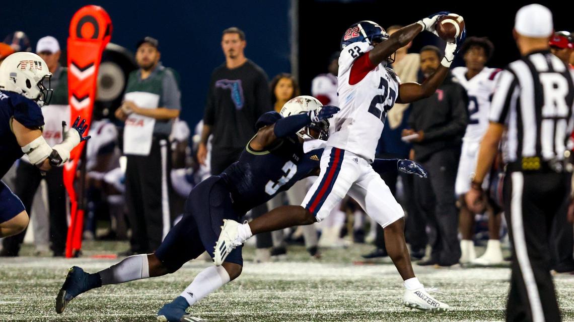 FAU running back Zuberi Mobley (22) makes the catch before being brought down by FIU linebacker Shaun Peterson Jr. (3) during the first half of the Shula Bowl at Riccardo Silva Stadium in Miami, Florida, on Saturday, November 12, 2022.