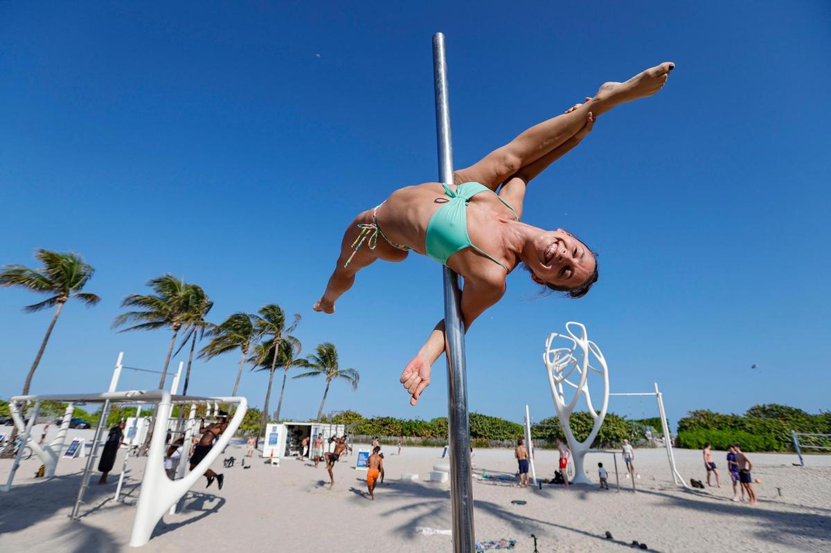 Lucilla Gonzalez works on her pole fitness on South Beach during spring break on Miami Beach, Florida on Sunday, March 17, 2024.