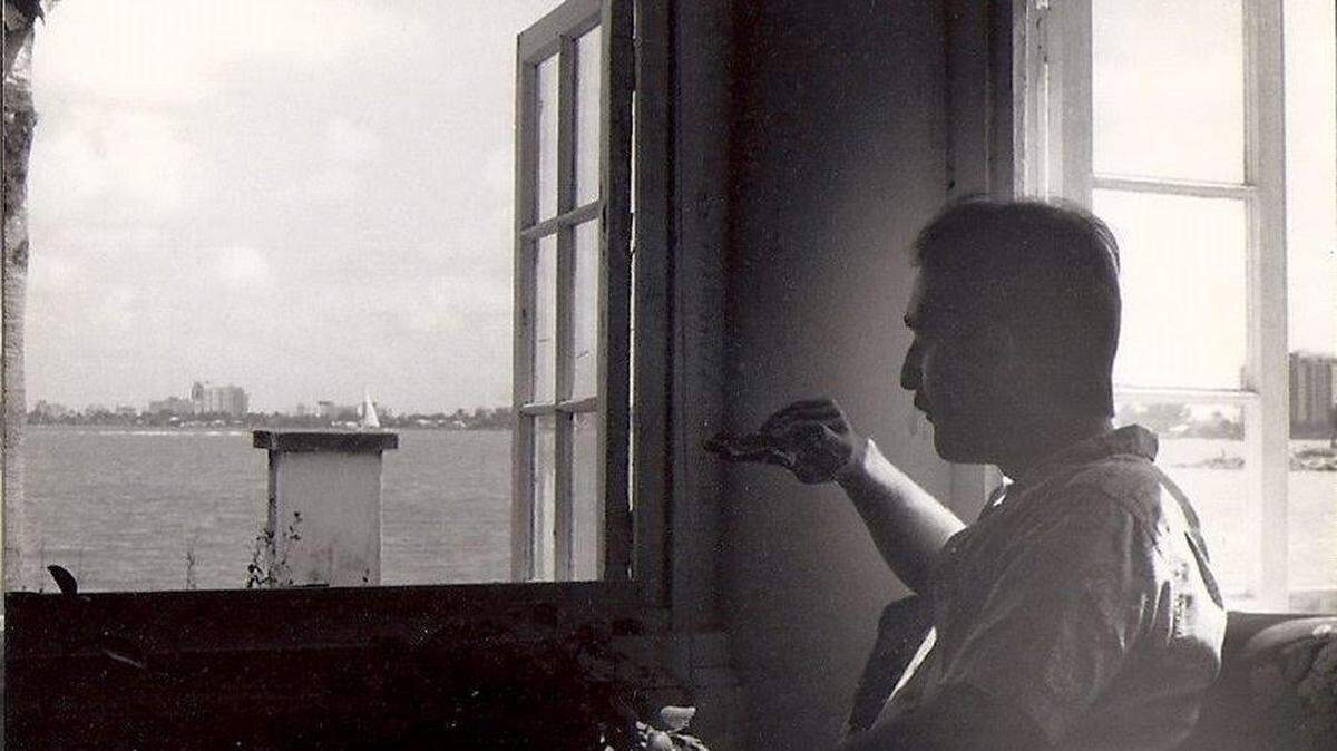 Author Timothy F. Schmand eating pizza while looking out window on North Bayshore Drive.