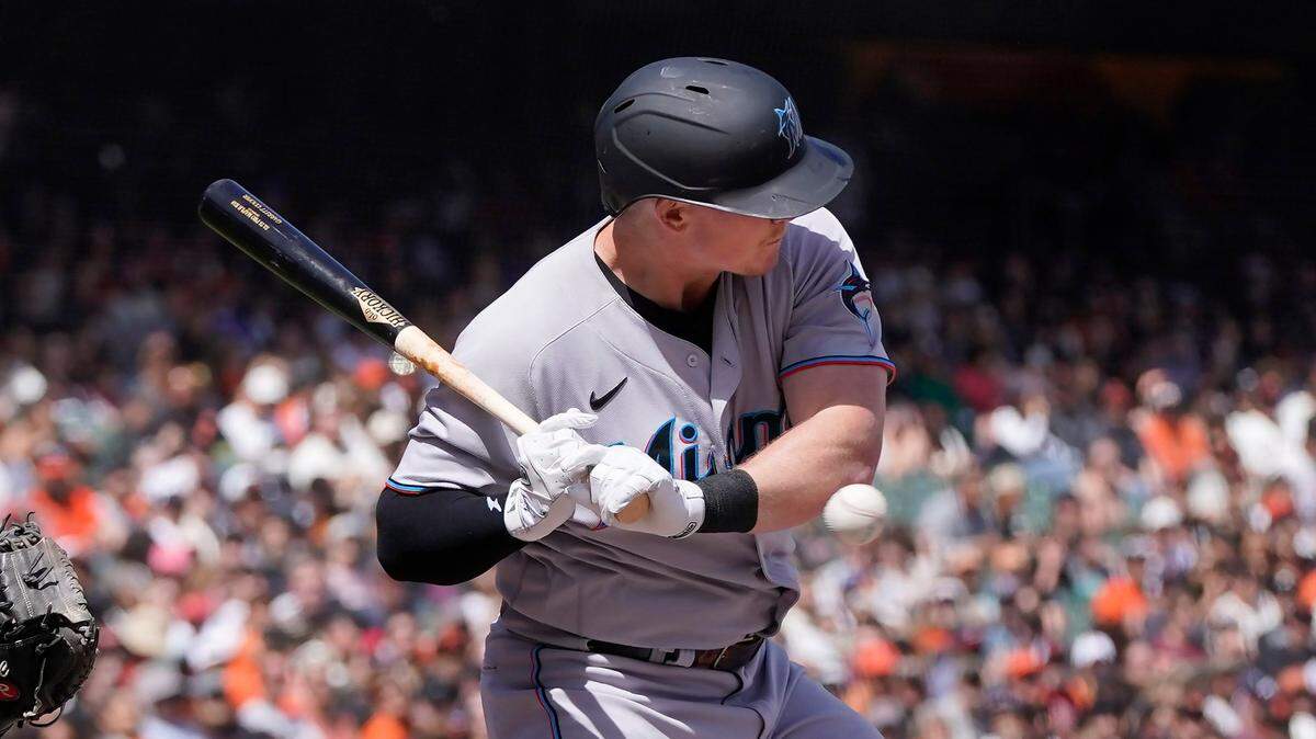 Miami Marlins’ Garrett Cooper is hit by a pitch from San Francisco Giants pitcher Anthony DeSclafani during the fourth inning of a baseball game in San Francisco, Sunday, April 10, 2022.