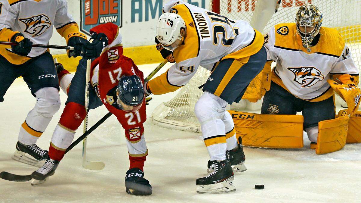 Florida Panthers Alex Wennberg (21) tries to stay up as he fights with Nashville Predators Jarred Tinordi (24) in front of the goal in the first period at the BB&T Center in Sunrise, Florida, Thursday, February 4, 2021.