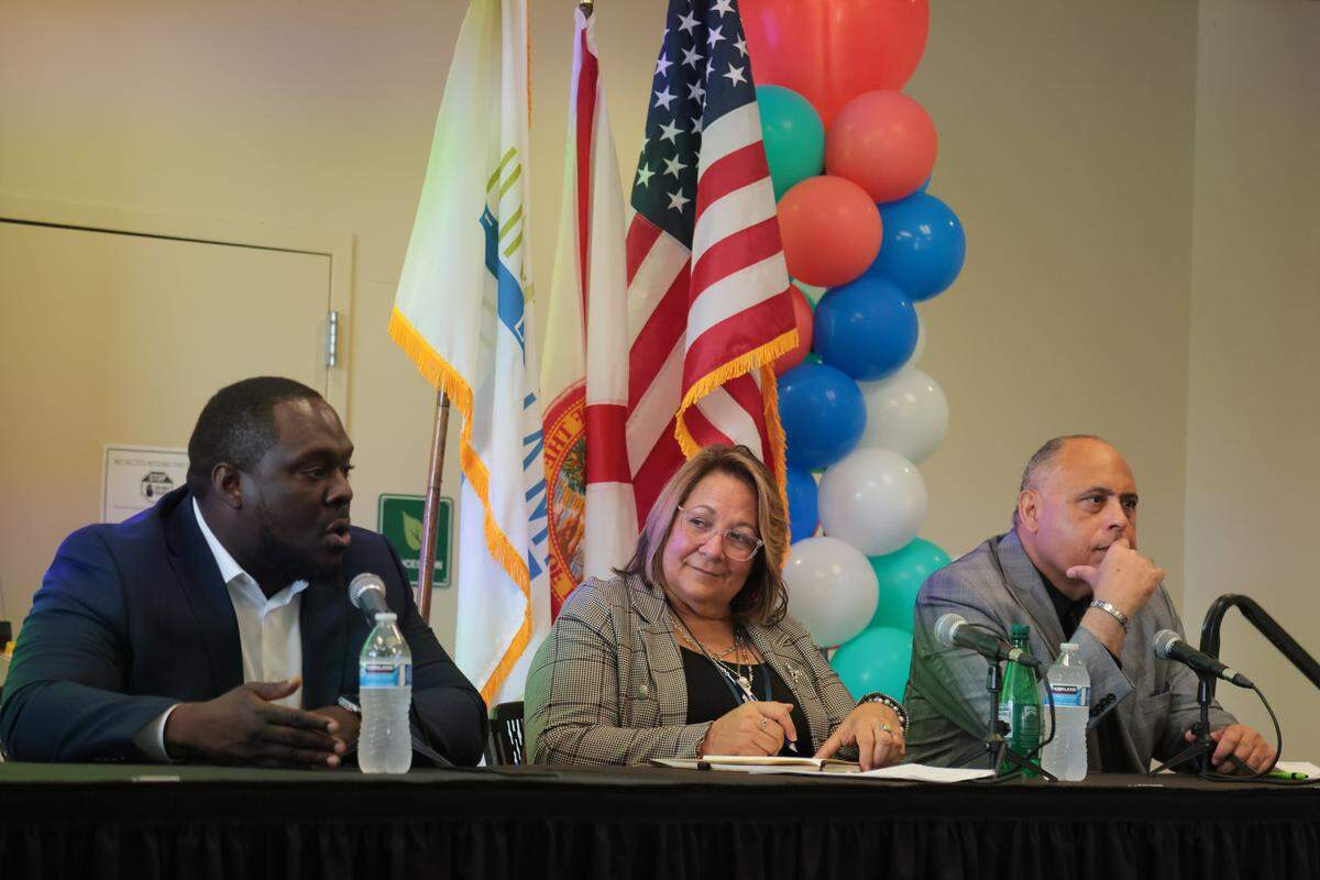 City of North Miami Development Services Director Debbie Love, center, takes notes as economic development director John Lorfils, left, speaks to an audience of business owners during the City of North Miami District 4 Small Business Expo at the Joe Celestin Center at 1525 NW 135th St. in North Miami, Florida, Friday, August 22, 2025.