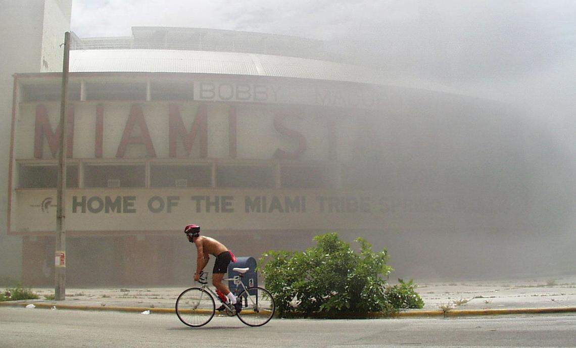 A bicyclist rides in front of Bobby Maduro Stadium after part of the old stadium caught fire. Firefighters had not yet arrived.