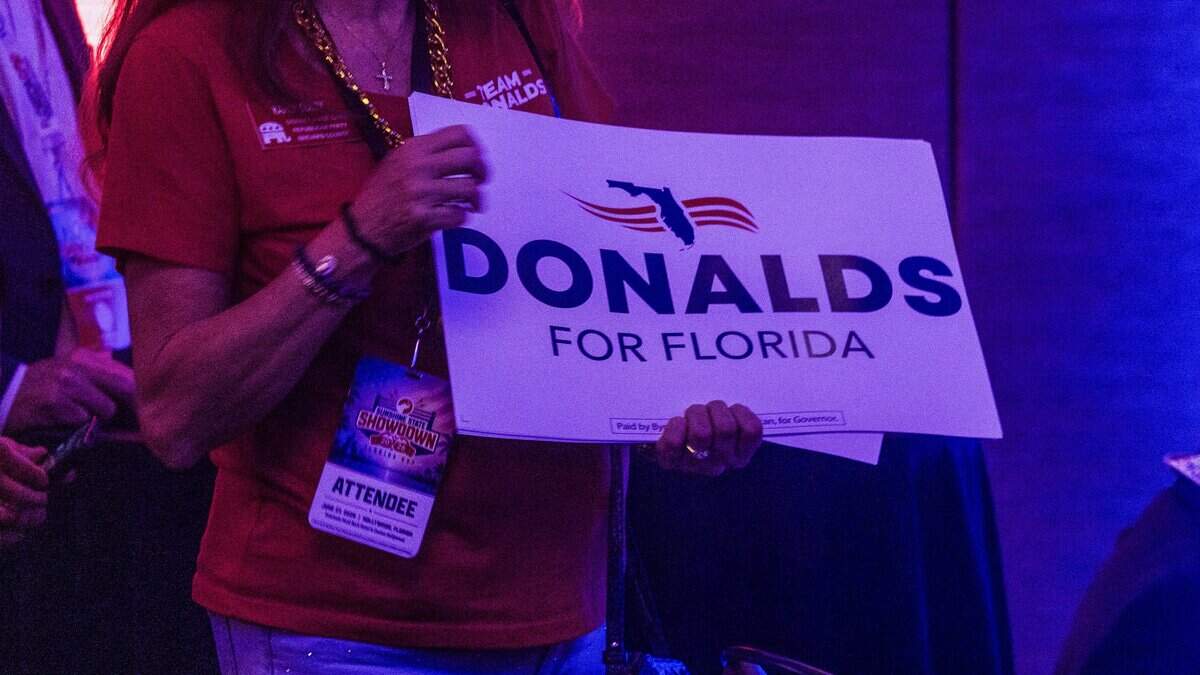 A supporter of Florida Congressman and gubernatorial candidate Byron Donalds hands out campaign posters during the Republican Party of Florida Sunshine State Showdown event, at the Seminole Hard Rock Hotel & Casino in Hollywood,  June 27, 2026.