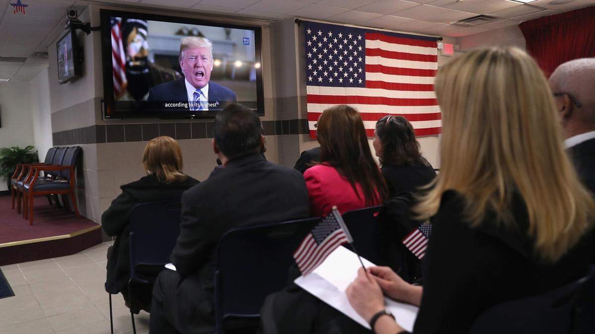 New American citizens watch a congratulatory video from President Donald Trump at a naturalization ceremony on February 2, 2018 in New York City. U.S. Citizenship and Immigration Services (USCIS) swore in 128 immigrants from 42 different countries during the ceremony at the downtown Manhattan Federal Building.