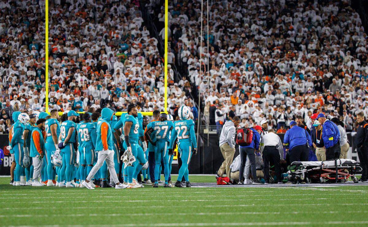 Los jugadores de los Miami Dolphins se paran junto a su compañero de equipo, el quarterback Tua Tagovailoa (1), después de que se lesionara en una jugada durante el segundo cuarto del partido de football de la NFL contra los Cincinnati Bengals en el Paycor Stadium, el jueves 29 de septiembre de 2022 en Cincinnati, Ohio.