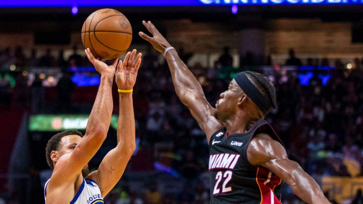 El armador de los Warriors, Steph Curry (izq.), dispara sobre el delantero del Heat, Jimmy Butler, en el partido celebrado el 1ro de noviembre de 2022 en el FTX Arena de Miami.