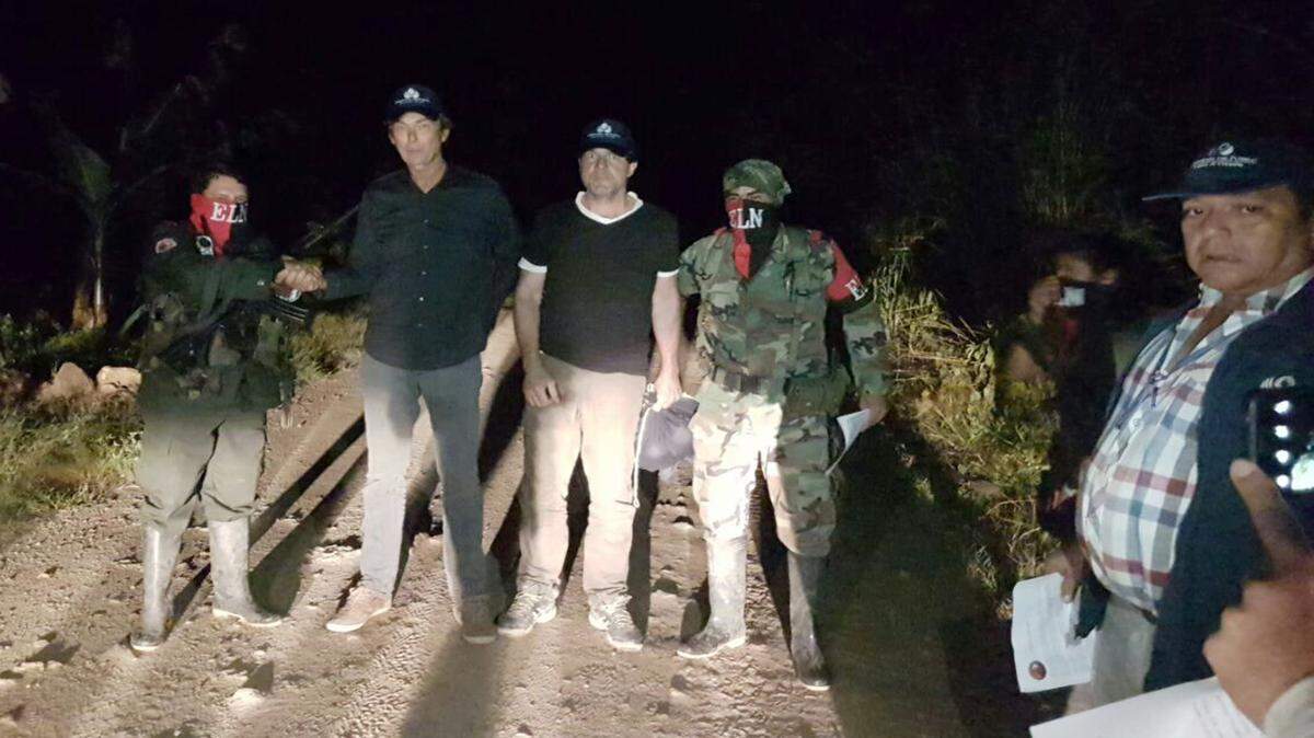 In this photo released by Colombia's Ombudsman Press Office, rebels of the Colombia's National Liberation Army rebel group, ELN, release Dutch journalists Derk Bolt, second from left, and Eugenio Follender, second from right, north of Santander, Colombia, Saturday, June 24, 2017. The two Dutch journalists, who were held captive for almost a week by the leftist rebels in Colombia, were released unharmed, Dutch Foreign Affairs Minister Bert Koenders said early Saturday.  