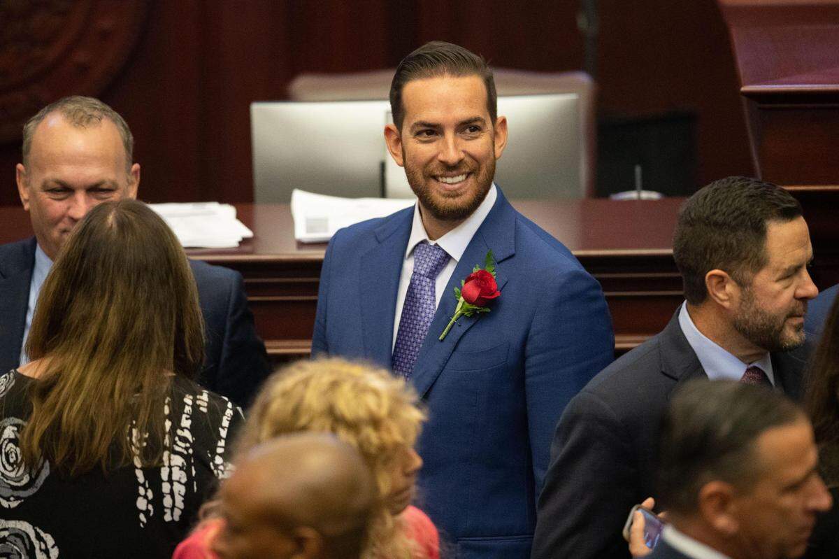Rep. Daniel Perez smiles while talking with other representatives prior to the joint session on the opening day of the 2023 Florida Legislative Session, Tuesday, March 7, 2023.