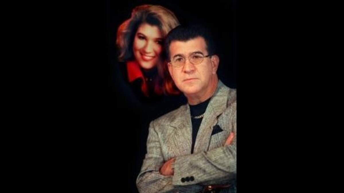 Luis Melendi stands next to the last studio portrait he took of his daughter.