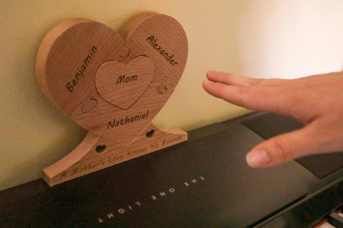 Danielle Tallafuss shows a Mother’s Day gift that her husband gave her on display above the piano in their bedroom at the Tallafuss family’s Oveido home on Monday, Feb. 21, 2022. Her children’s names make up the pieces of the puzzle: Benjamin, 2, Alexander, 9 months, and Nathaniel, whom Danielle and her husband decided to protect from the toll of being born with hypoplastic left heart syndrome by terminating the pregnancy at 22 weeks. “A mother’s love knows no bounds,” reads the phrase on the bottom of the heart-shaped puzzle.