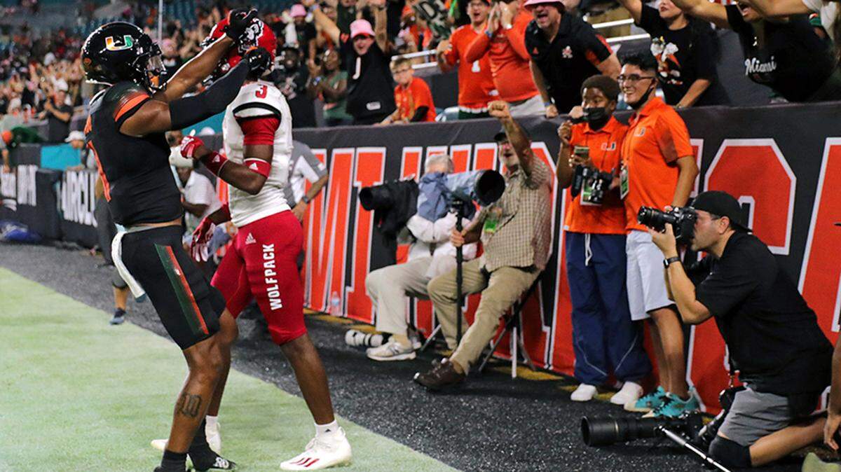 Miami Hurricanes fans show their support as Hurricanes wide receiver Charleston Rambo (11) celebrates after scoring a touchdown during the first quarter of their ACC football game against the North Carolina State Wolfpack at Hard Rock Stadium during an October home game.