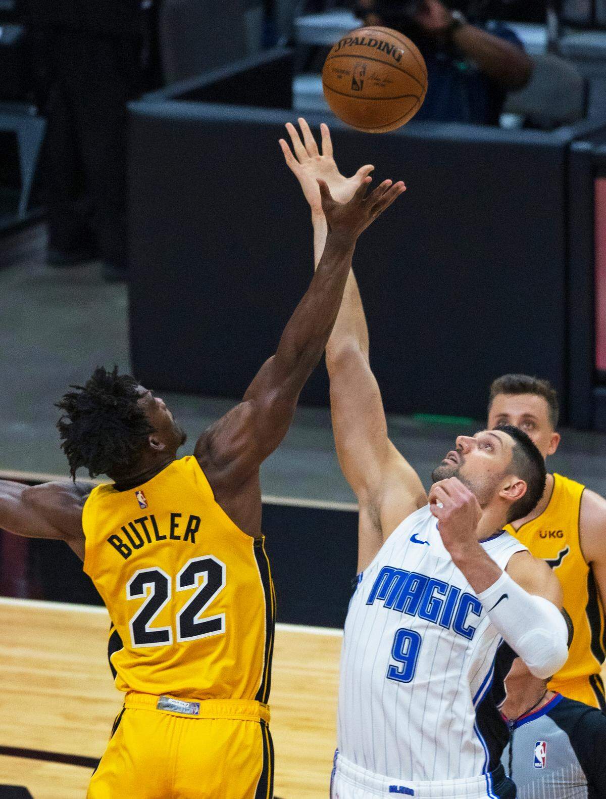 Miami Heat forward Jimmy Butler (22) and Orlando Magic center Nikola Vucevic (9) jump ball to start their NBA basketball game at the AmericanAirlines Arena on Thursday, March 11, 2021.