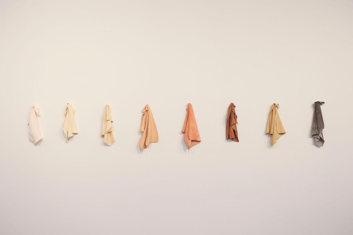 'Auburn, trapos de porcelana coloreados', de Juana Valdés cuelgan en la pared de la muestra de arte cubano Espacio 23 llamada 'Tú sabes quién eres' el martes 1 de noviembre de 2022, en Miami. Los trapos están hechos de porcelana china. El material se asocia típicamente con los ricos. 'Sin embargo, esta obra alude a cómo personas de todos los tonos de piel y todo tipo de individuos están involucrados con el material, ya sea que estén comiendo de él o sirviéndolo'. dijo una de las curadoras. Alie Skowronski askowronski@miamiherald.com