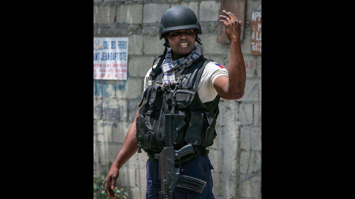 Port-au-Prince, June 23, 2022 - A Haitian National Police officer direct traffic at a Police checkpoint in Port-au-Prince.
