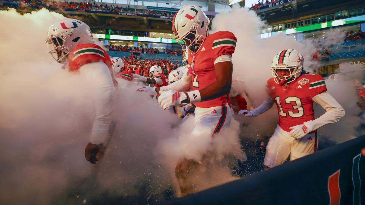 The Miami Hurricanes rush the field for their NCAA football game against the Louisville Cardinals at Hard Rock Stadium in Miami Gardens, Florida, on Friday, October 17, 2025.