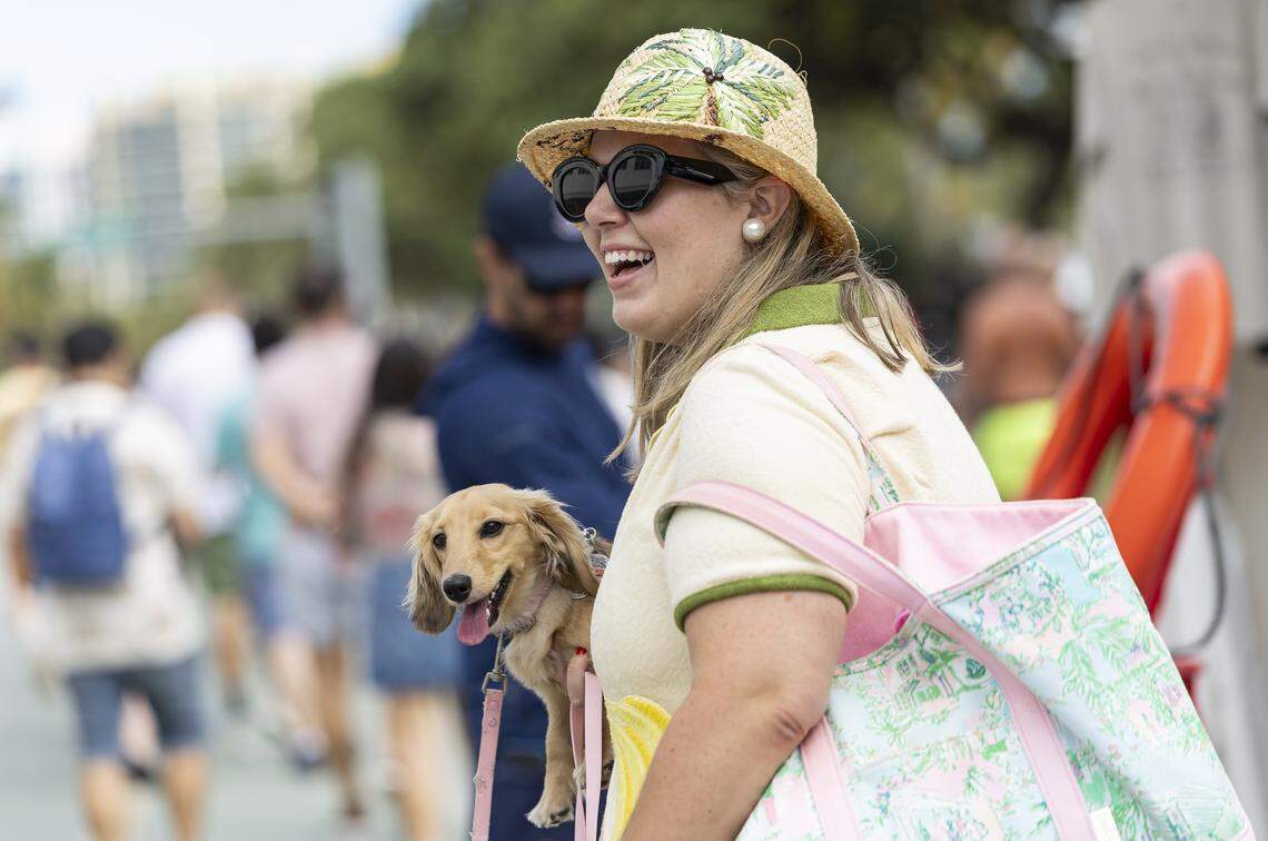 Maria Jurewicz is seen carrying her small dog, Martini, as she makes her way down Ocean Drive during Art Deco Weekend on Saturday, Jan. 10, 2026, in Miami Beach, Fla.