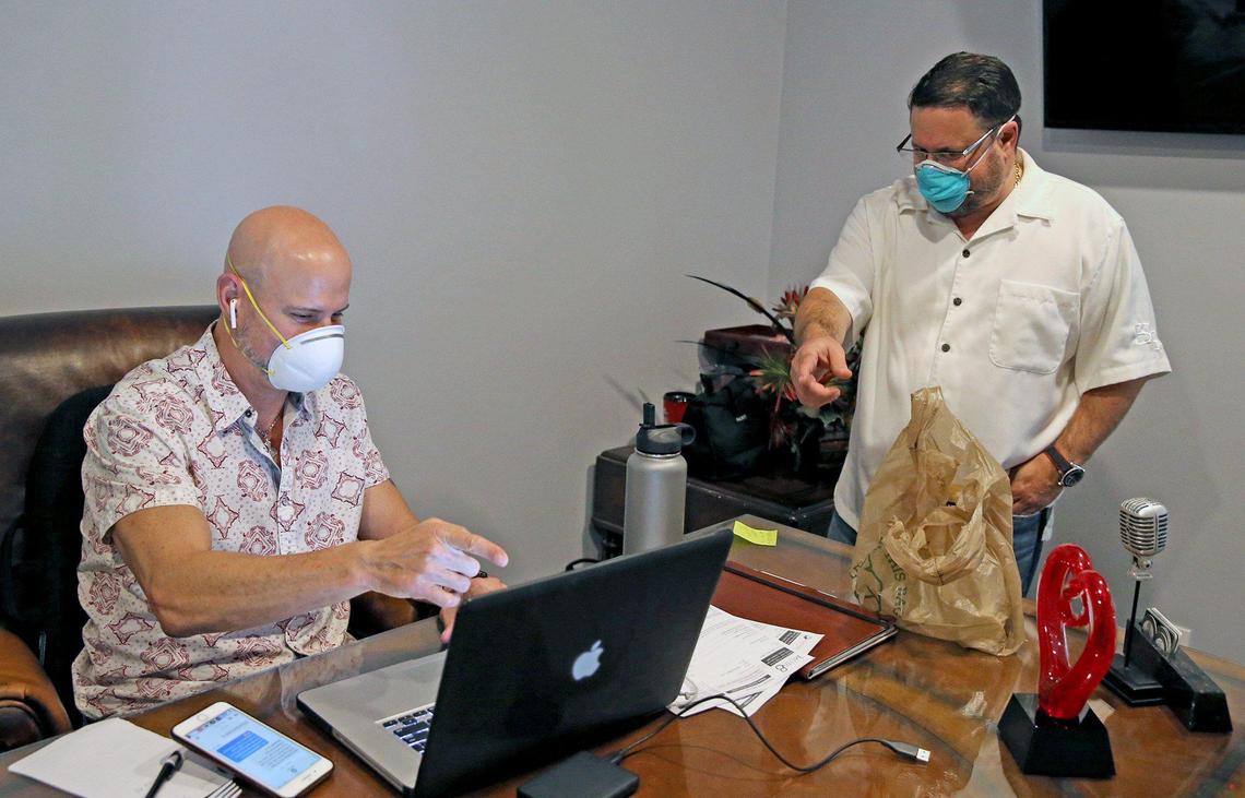 Event Services Group director of sales Jeffrey Gold and Managing Partner Wayne Labush talk six feet apart as they adjust their workplace relationships, April 8, 2020. The business kept workers on its payroll while waiting for a small business loan, but ultimately was forced to lay off dozens of workers as the pandemic dragged on.