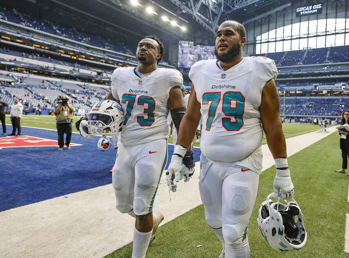 Miami Dolphins guard Austin Jackson (73) and offensive tackle Larry Borom (79) walk off the field after the Indianapolis Colts defeat the Dolphins 33-8 in an NFL game at Lucas Oil Stadium in Indianapolis on Sunday, September 7, 2025, in Indianapolis.