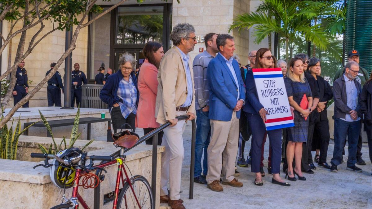 Funcionarios de la Policía de Coral Gables observan cómo un grupo de activistas protestaba el martes durante una reunión para discutir un acuerdo entre la ciudad de Coral Gables y el ICE .