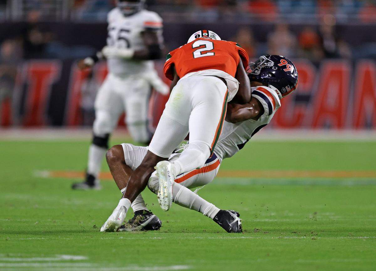Miami Hurricanes cornerback Tyrique Stevenson (2) tackles Virginia Cavaliers wide receiver Keytaon Thompson (99) during the first quarter of their ACC football game at Hard Rock Stadium on Thursday, September 30, 2021 in Miami Gardens, Florida.