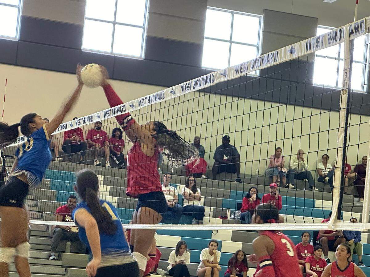 Cypress Bay’s Maria Martinez (left) and Doral Academy’s Isabella Frometa (right) meet at the net during a point in Saturday’s Region 4-7A semifinal volleyball playoff at West Broward High School in Pembroke Pines, Fla.