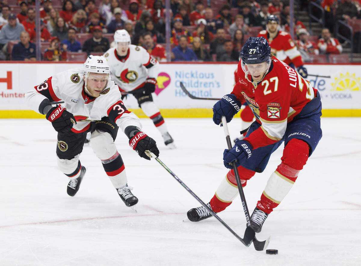 Florida Panthers center Eetu Luostarinen (27) keeps the puck from Ottawa Senators defenseman Nikolas Matinpalo (33) during the third period of a game on Florida Panthers Pride Night on Tuesday, March 31, 2026, at Amerant Bank Arena in Sunrise, Fla.