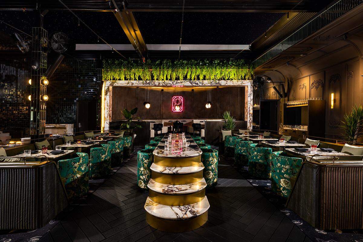The main dining area of Giselle features greenery and wood paneling and can seat parties of any size, from intimate tables for two to tables for 10.