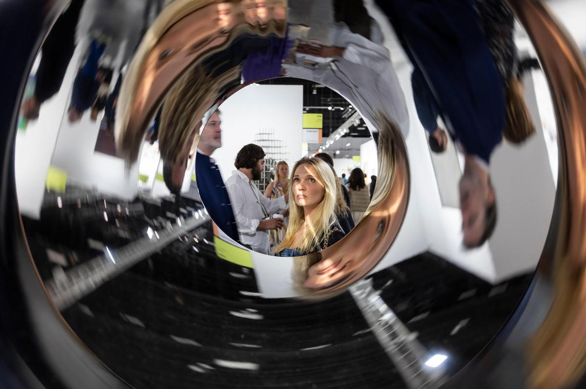 Eda Ozdoyuran, from Istanbul, looks through Alicja Kwade’s ‘Tunnel-Tell’ presented by OMR during Art Basel at the Miami Beach Convention Center on Wednesday, Dec. 4, 2024, in Miami Beach, Fla.