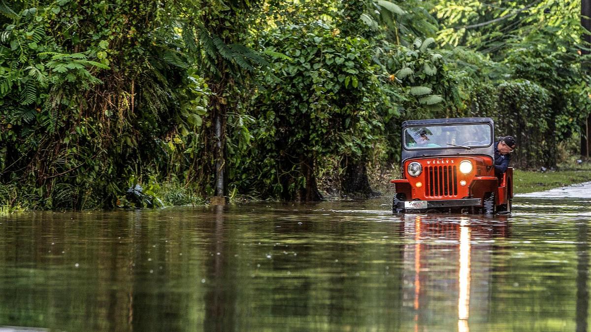On Sept. 20, 2022, Juan Antonio Molina drives his jeep through a road flooded in Toa Alta by Hurricane Fiona that passed by Puerto Rico on Sept. 18.