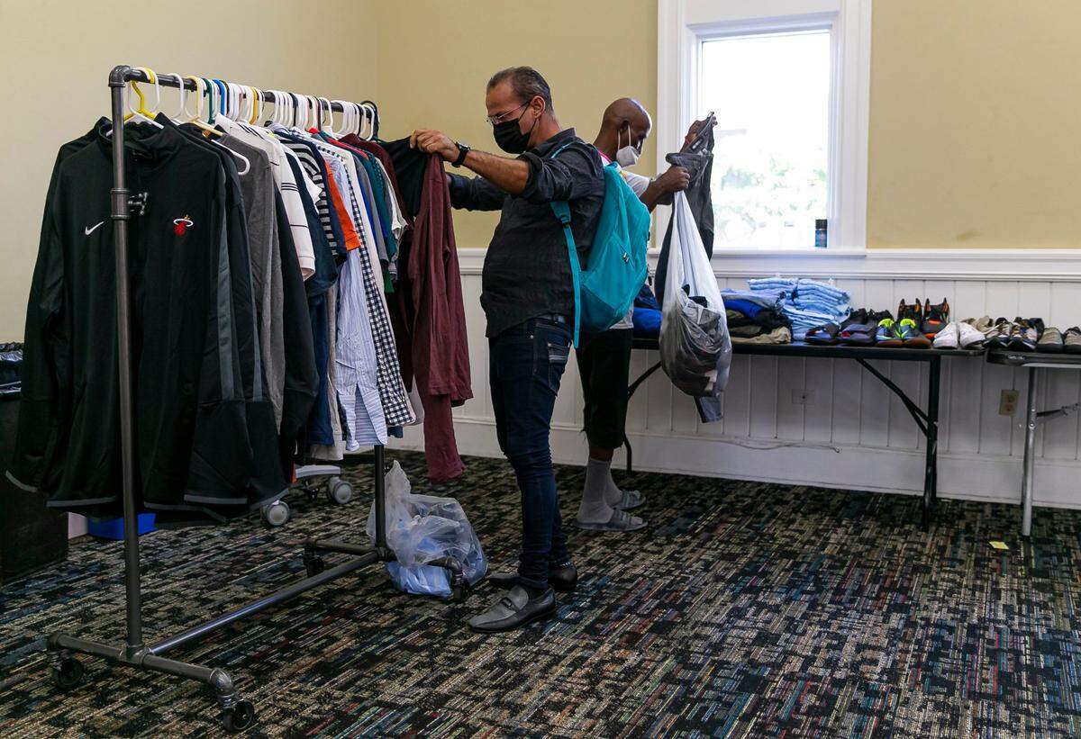 Asnay Darraido, 46, left, and Alfonso Buckley, 66, look through clothes as part of the Chapman Partnership’s Mobile Closet program in downtown Miami.