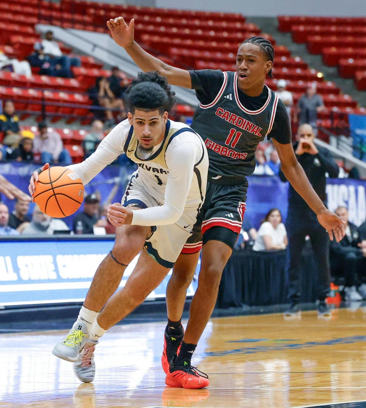 Calvary Christian Academy’s Shon Abaev (1) drives the ball as Cardinal Gibbons’ Evan Wyche (11) defends in the first half during boys 3A basketball semifinal game of the Florida High School State Championships at the RP Funding Center in Lakeland, Florida on Friday, February 28, 2025.
