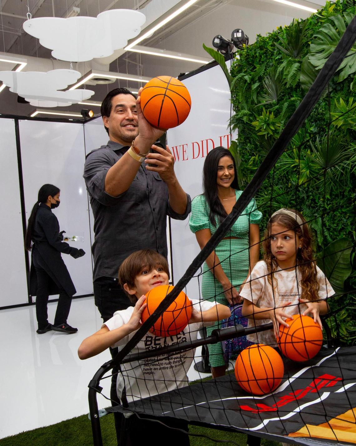 A family shoots toy basketballs before a moderated discussion with Dwyane Wade for his new memoir “Dwyane.” at The Shop Miami in the Wynwood neighborhood of Miami, Florida, on Friday, November 19, 2021.