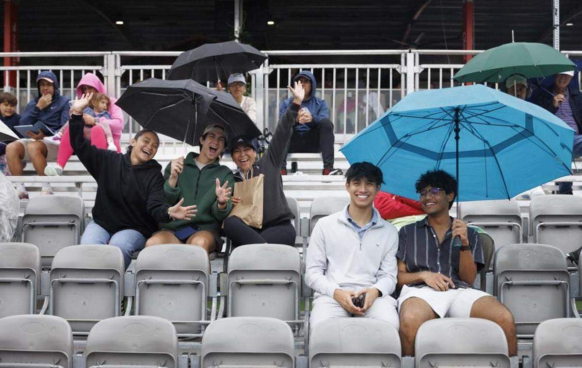 Fans wait in the rain at the Butch Buchholz court as staff tries to clear water from the court during a rain delay at the Miami Open on Wednesday, March 18, 2026, at Hard Rock Stadium in Miami Gardens, Fla.