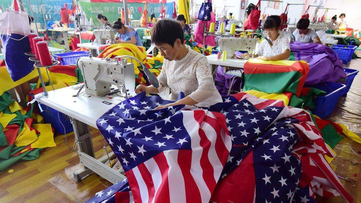 Employees sew U.S. flags at a factory in China’s eastern Anhui province. Many American companies are thinking about leaving China because of the COVID-19 pandemic.