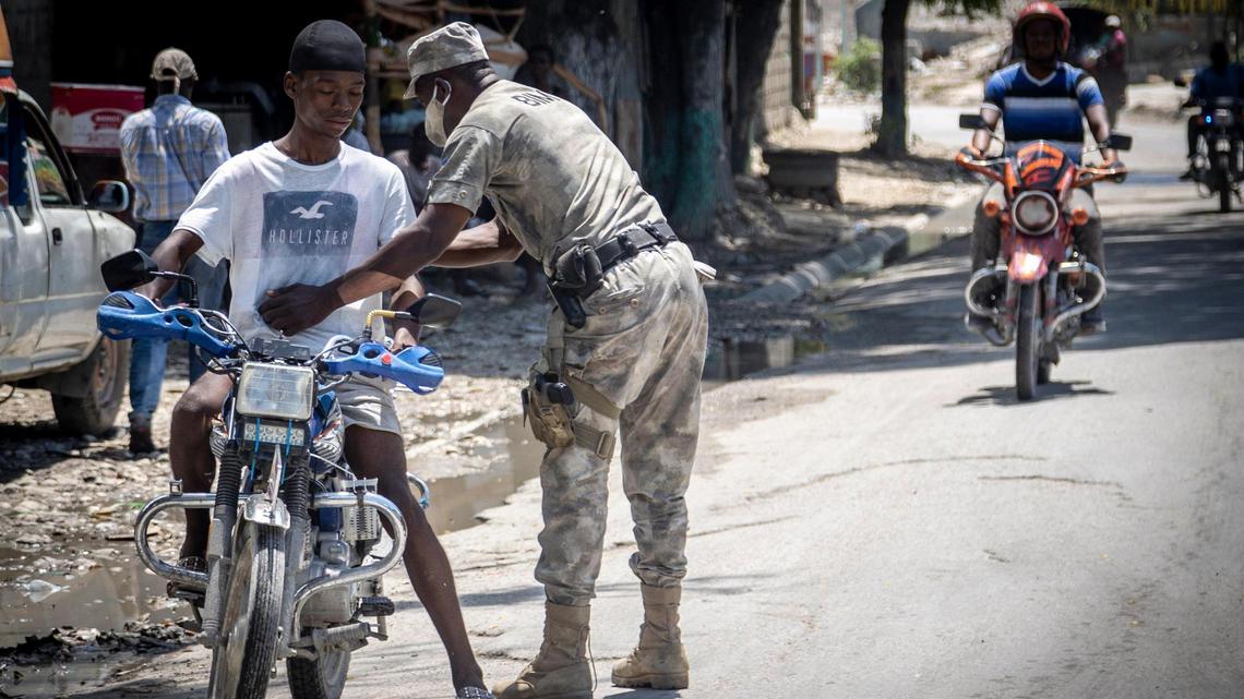 In 2022, a police officer frisks a motorcyclist at a checkpoint in Butte-Boyer 75, where a deadly gang war had erupted in late April.